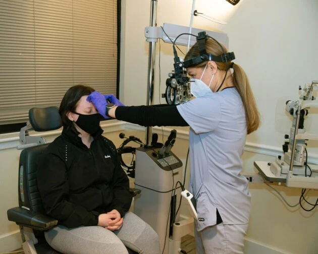 A doctor examines a patient's eyes.